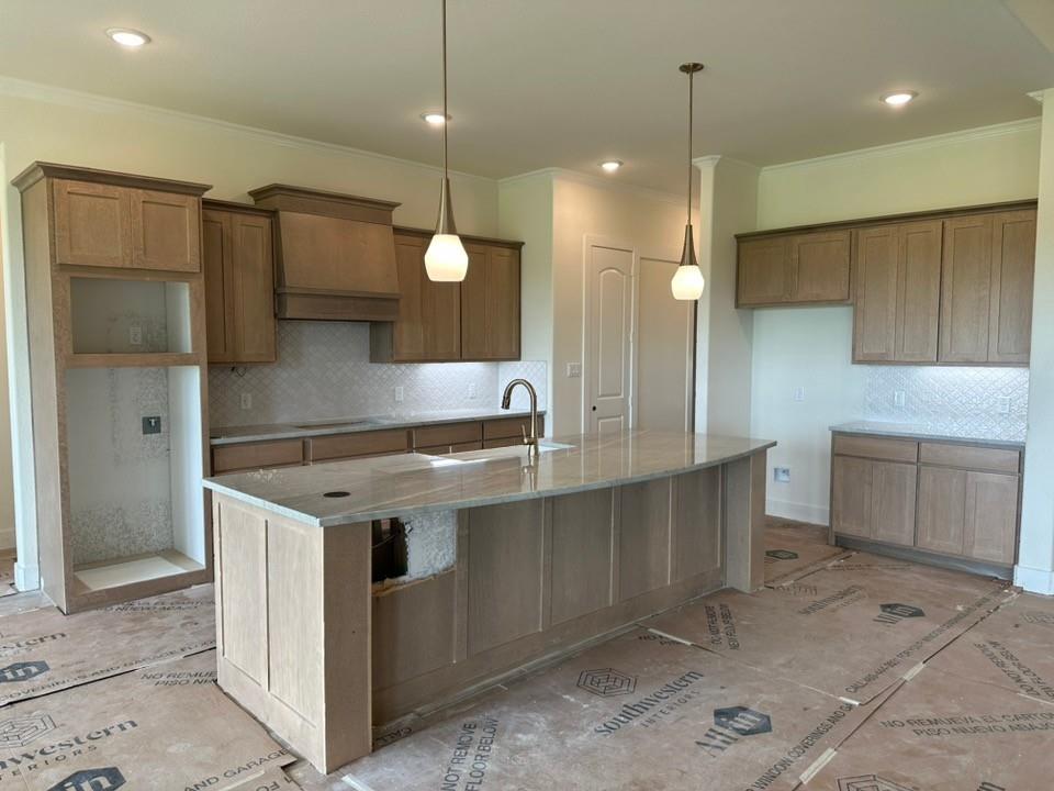 205 Cobb Road Leonard, TX 75452 - Photo 10 of 28 Spacious kitchen featuring light wood-finish cabinetry, a large center island with a light-colored countertop, and a patterned tile backsplash