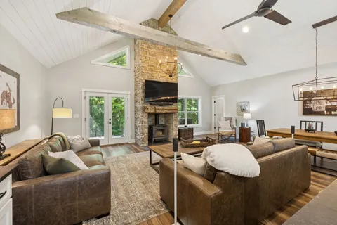a view of a dining room with furniture wooden floor chandelier and fireplace