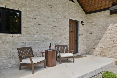 a living room with furniture a fireplace a lamp and a large window