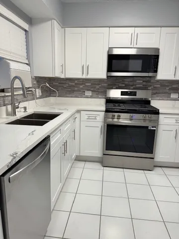 a white refrigerator freezer and a stove sitting inside of a kitchen