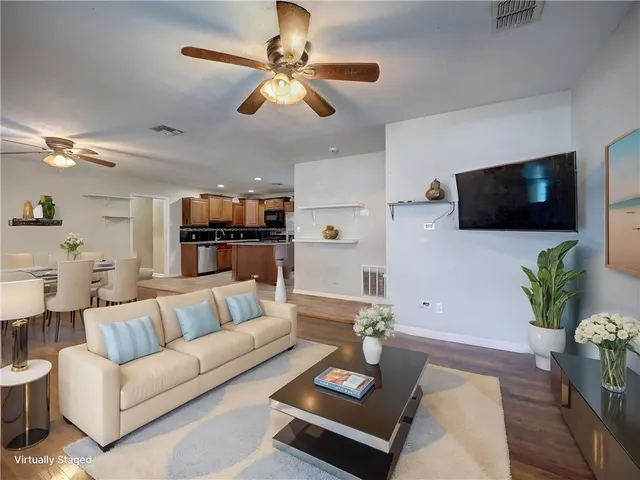 a living room with furniture a chandelier and a rug