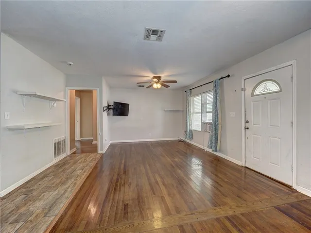 a living room with furniture kitchen view and a flat screen tv