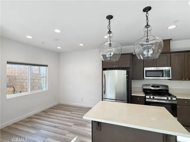 a kitchen with stainless steel appliances a stove refrigerator and microwave