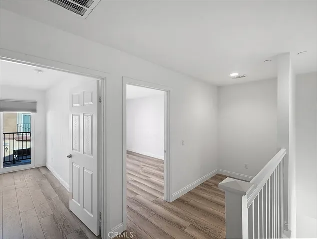 a view of a hallway with wooden floor and closet