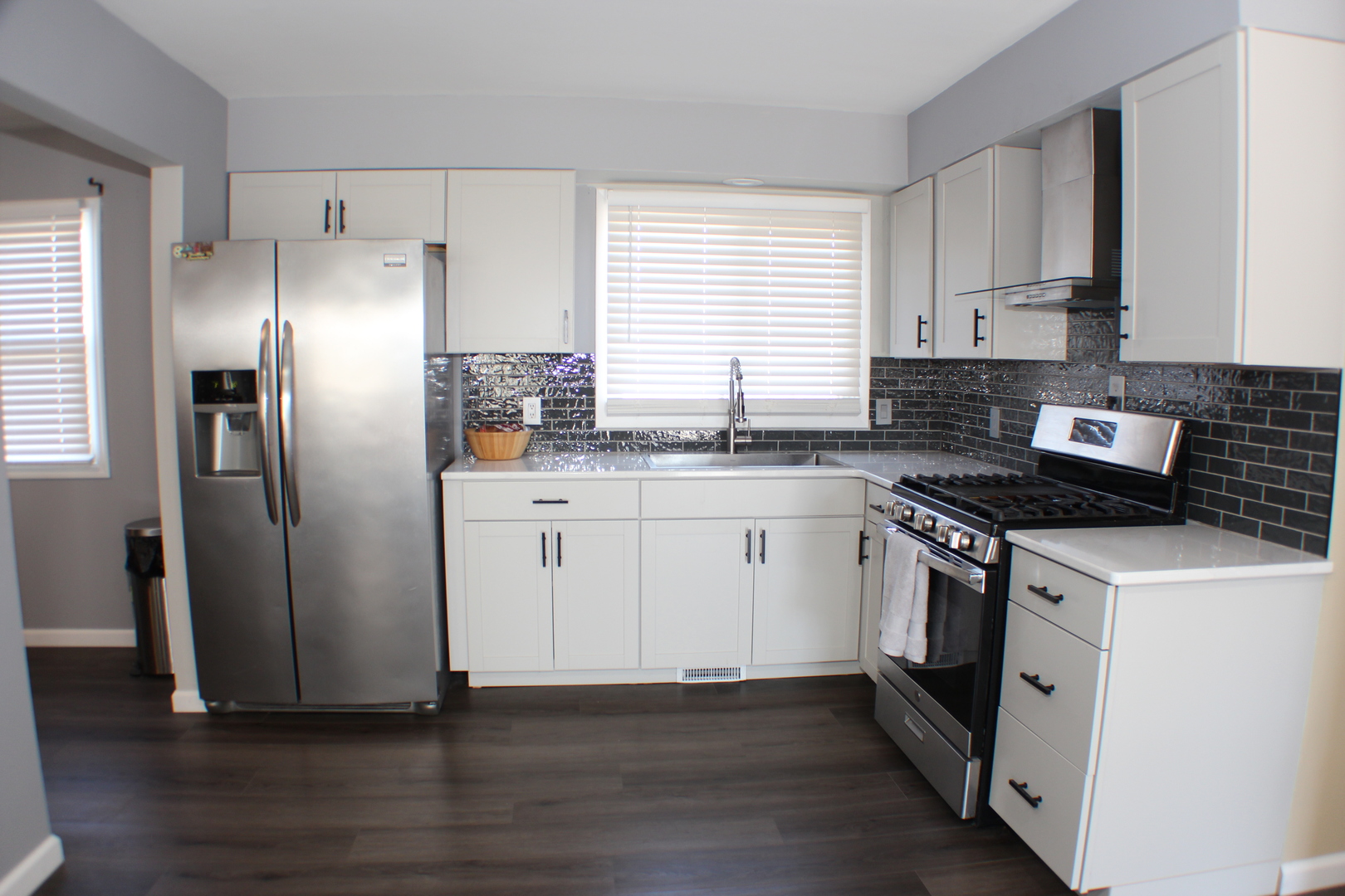 5113 44th Avenue Moline, IL 61265 - Photo 6 of 30 a kitchen with stainless steel appliances granite countertop a refrigerator a sink a stove and white cabinets with wooden floor