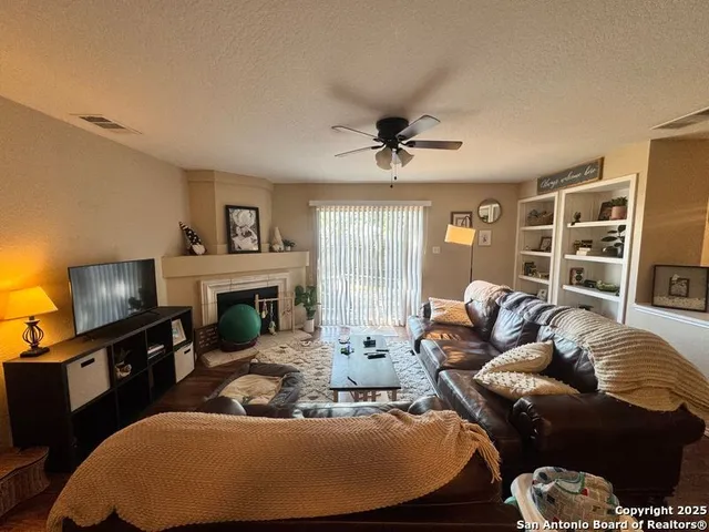 a living room with furniture a fireplace and a flat screen tv