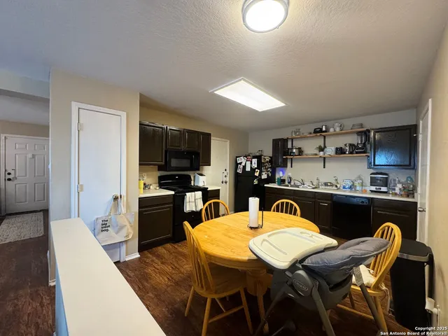 a kitchen with kitchen island a dining table and chairs