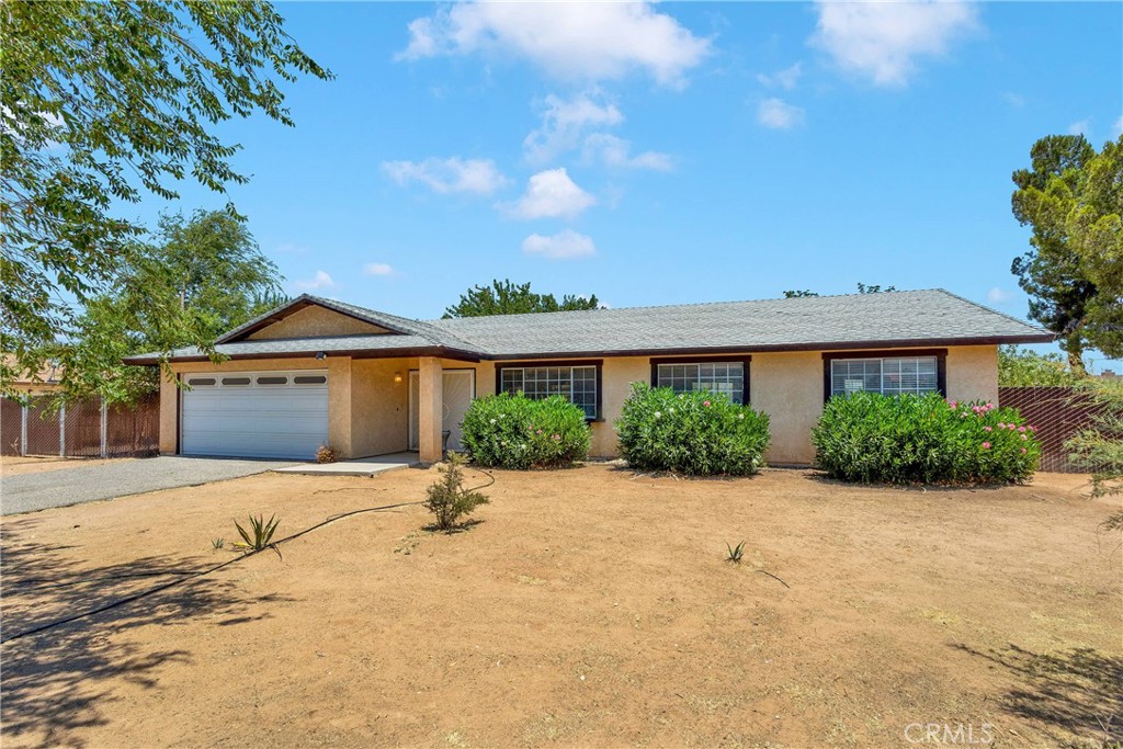 12243 Snapping Turtle Road Apple Valley, CA 92308 - Photo 1 of 1 a front view of house with yard and trees in the background