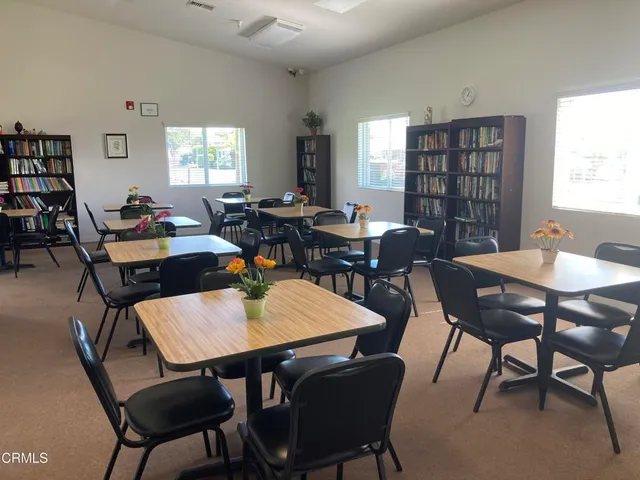 a room with lots of white furniture and a large window