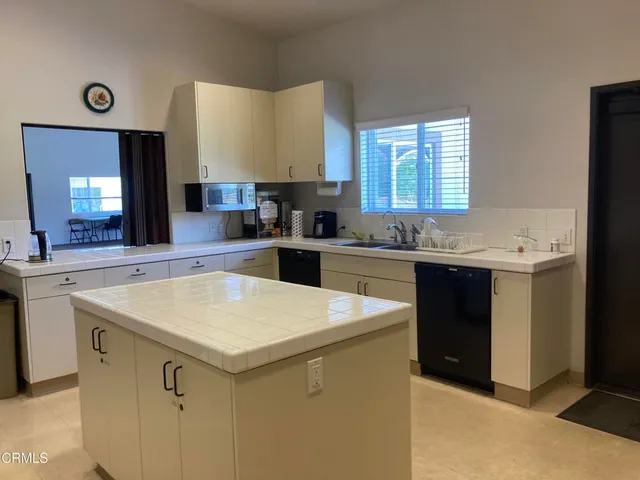 a kitchen with a table chairs sink and cabinets