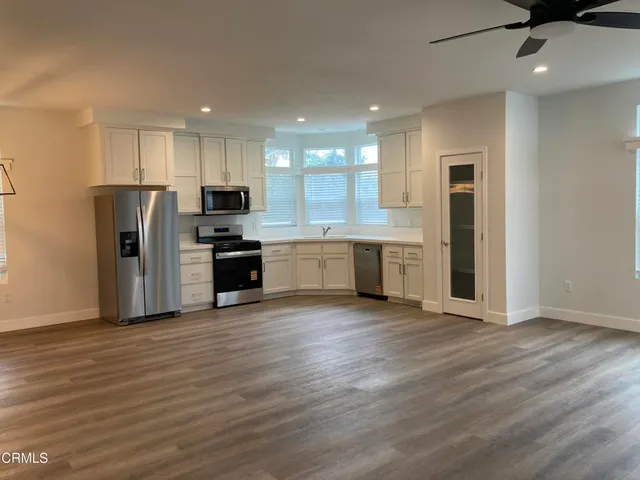 a view of kitchen with wooden floor and electronic appliances