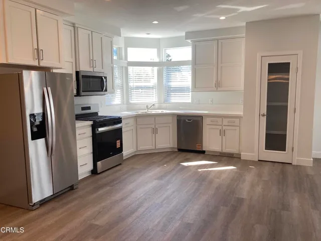 a kitchen with stainless steel appliances granite countertop a stove a sink and a refrigerator