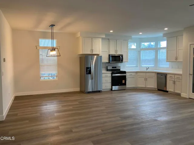 an empty room with window and wooden floor