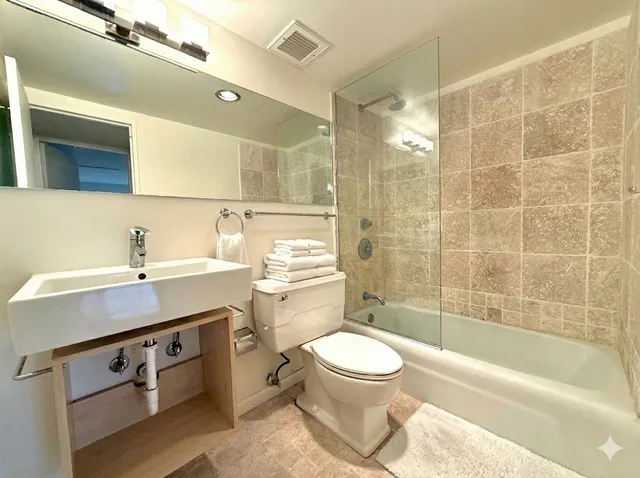 a bathroom with a sink a toilet and shower
