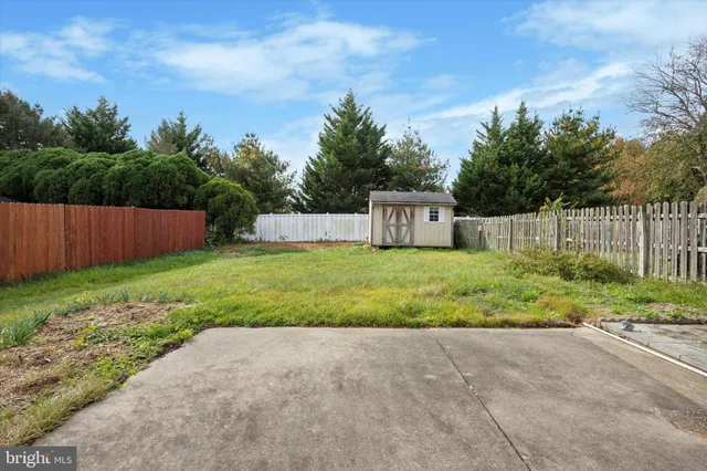 a house view with a garden and wooden fence