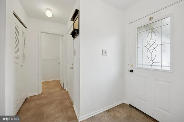 a view of hallway with wooden floor and cabinet