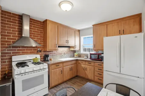 a kitchen with a sink a stove a refrigerator and cabinets
