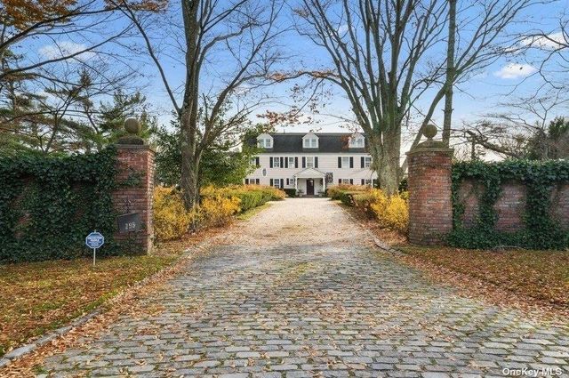 a front view of a house with a yard and tree s