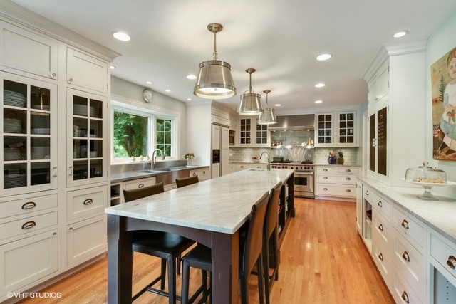 1719 Spring Creek Road Barrington Hills, IL 60010 - Photo 2 of 26 a large kitchen with kitchen island a island a stove a sink a dining table and chairs