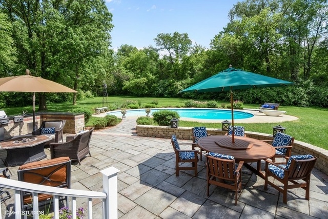1719 Spring Creek Road Barrington Hills, IL 60010 - Photo 9 of 26 a view of patio with chairs and table under an umbrella