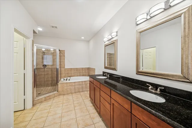 a large bathroom with double vanity and a bathtub