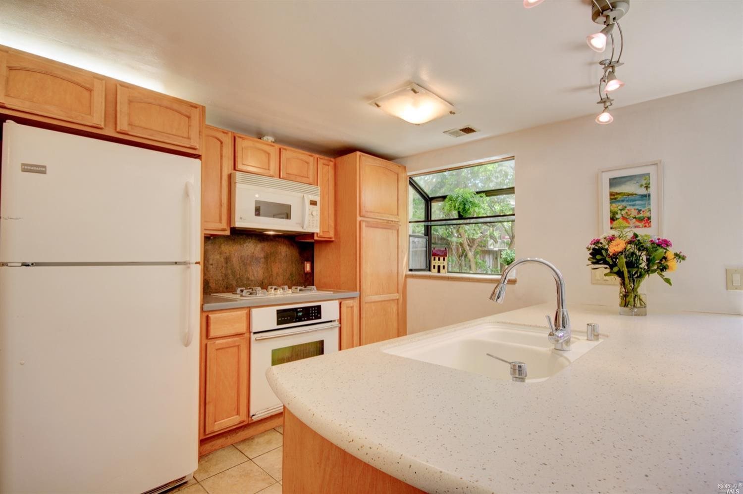 297 Playa Del Rey San Rafael, CA 94901 - Photo 1 of 1 a kitchen with stainless steel appliances kitchen island granite countertop a refrigerator a sink dishwasher a stove with white cabinets and wooden floor