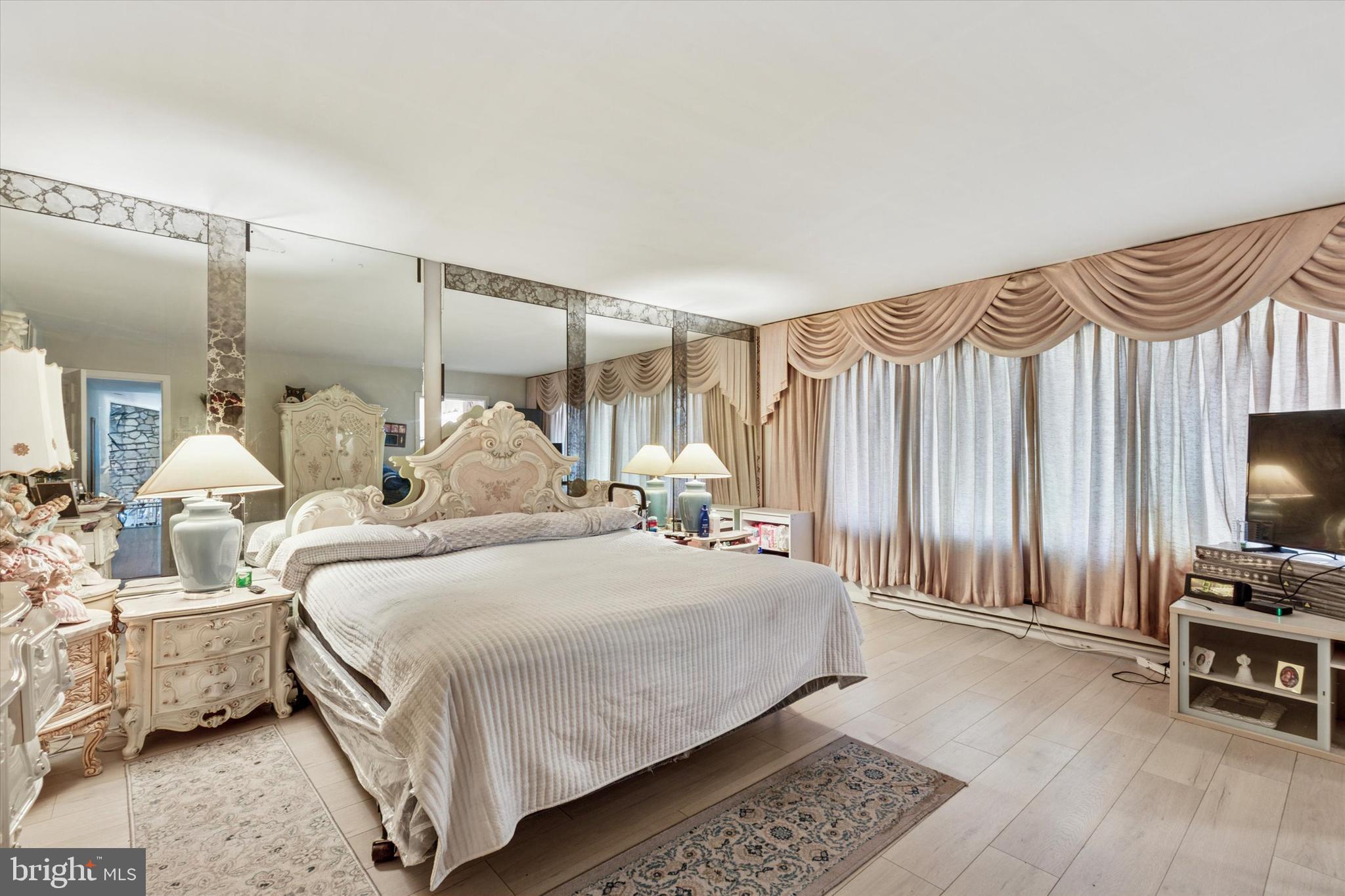 290 Hatboro Road Ivyland, PA 18974 - Photo 12 of 45 a bedroom with a bed a large window and a flat screen tv