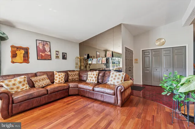 a living room with furniture potted plant and a wooden floor