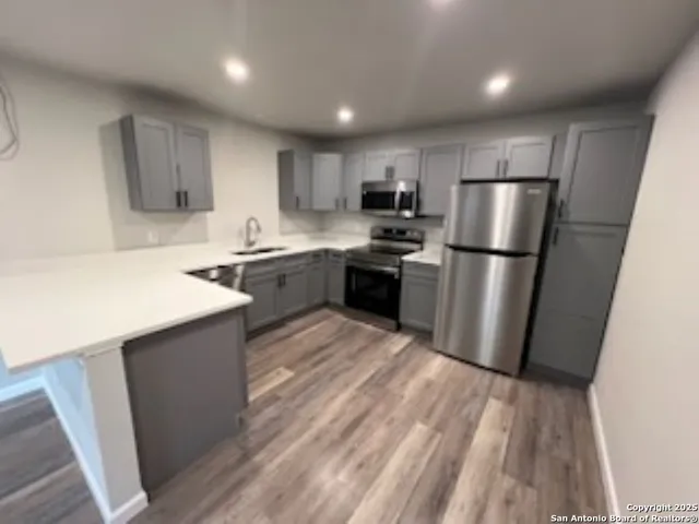 a kitchen with stainless steel appliances a refrigerator a sink a stove a microwave and cabinets