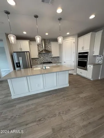 a large kitchen with kitchen island a sink stainless steel appliances and cabinets