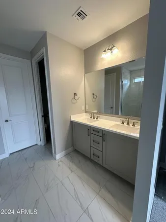 a bathroom with a double vanity sink a mirror and a bathtub