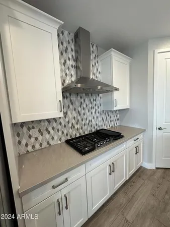 a kitchen with stainless steel appliances a stove and white cabinets