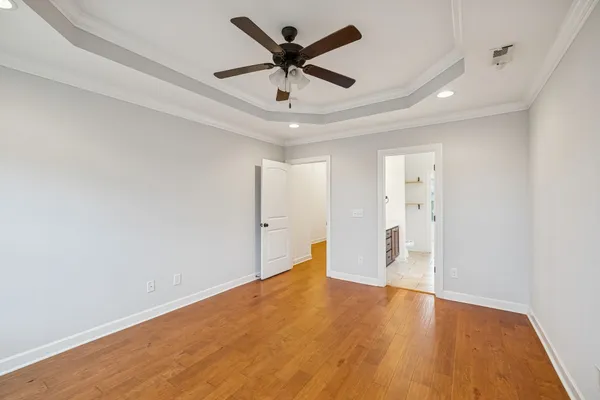 a view of an empty room and cabinet with wooden floor