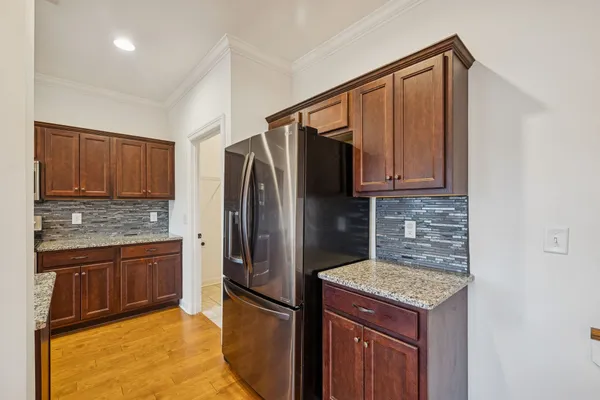 a kitchen with stainless steel appliances granite countertop a refrigerator a stove and a sink