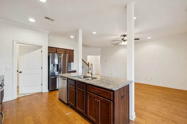 a kitchen with stainless steel appliances granite countertop a sink and a refrigerator
