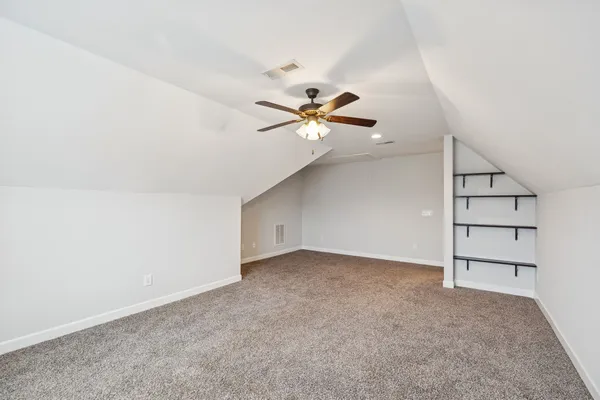 an empty room with closet and windows