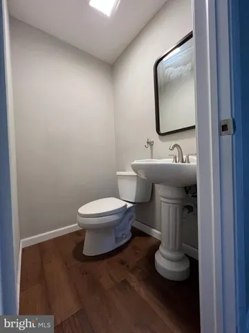 a bathroom with a toilet a sink and mirror