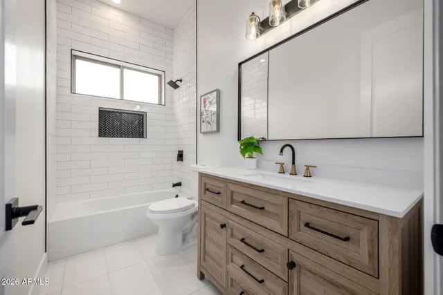 a bathroom with a double vanity sink toilet mirror and shower