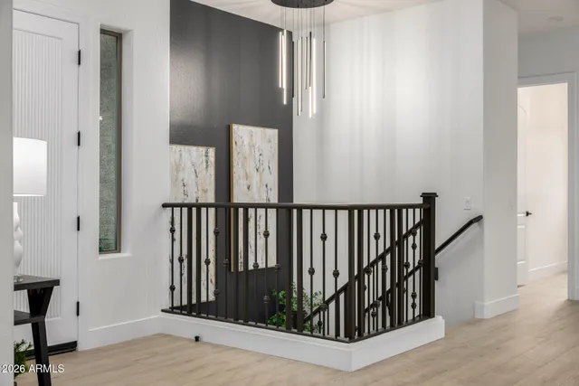 a view of a hallway with wooden floor and stairs