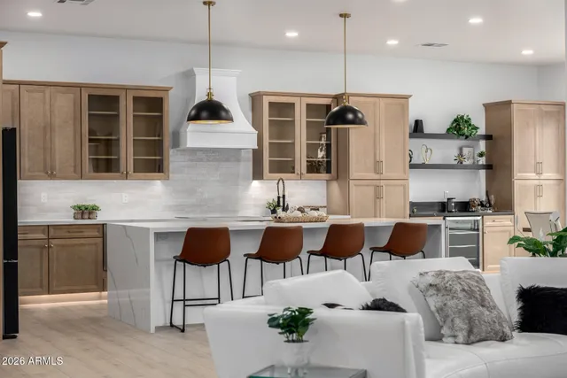 a kitchen with kitchen island granite countertop a stove a sink a oven a dining table and chairs