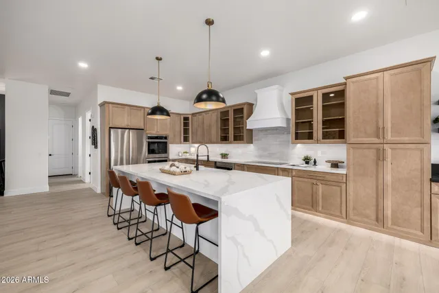 a kitchen with kitchen island a dining table chairs sink and white appliances