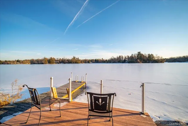 a view of a lake with table and chairs