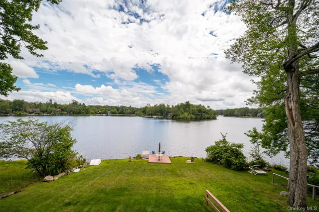 a view of a swimming pool with lawn chairs and a yard