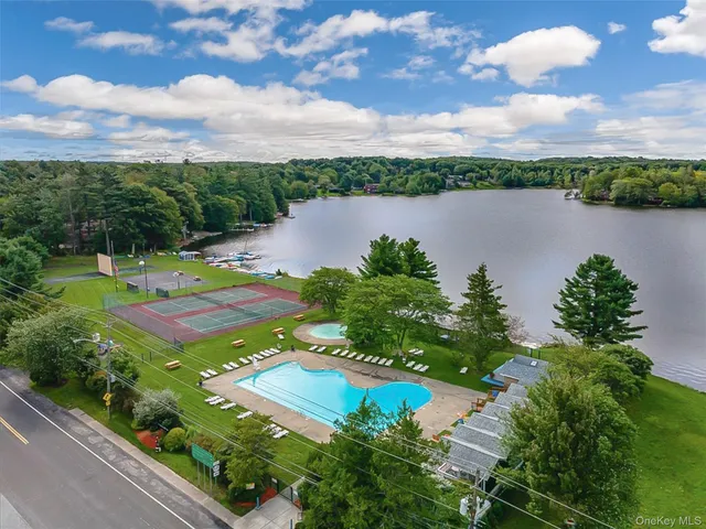 an aerial view of a house with garden space and lake view in back