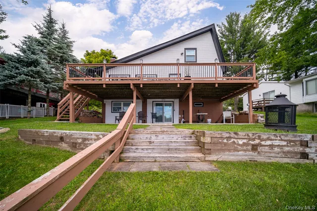 an aerial view of a house with garden space and lake view in back