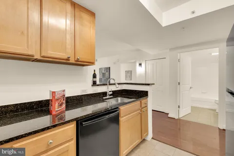 a kitchen with stainless steel appliances granite countertop a sink and cabinets with wooden floor