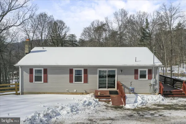 a view of a house with a yard covered in snow