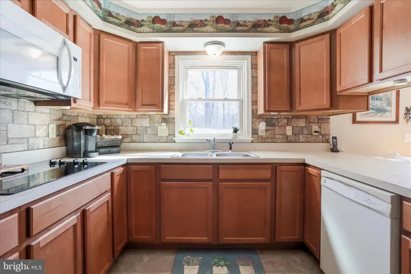 a kitchen with stainless steel appliances granite countertop a sink and a refrigerator