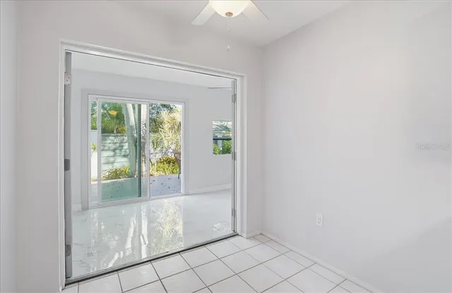 a view of an empty room with wooden floor and windows