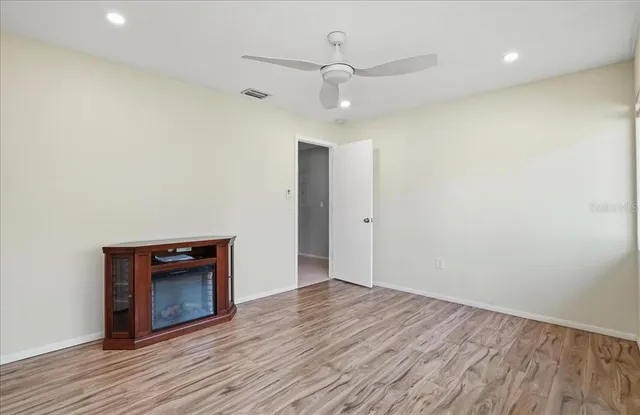 a view of a patio with table and chairs potted plants and floor to ceiling window
